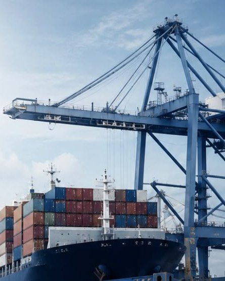 Porte-conteneurs à quai et conteneur ouvert rempli de cartons